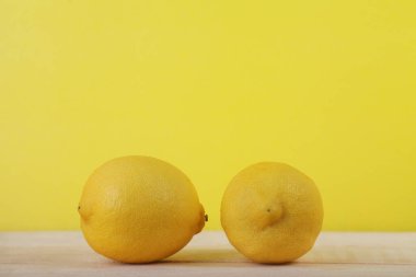 Tahta ve sarı arka planda taze limon meyvesi