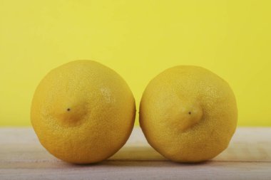 Tahta ve sarı arka planda taze limon meyvesi