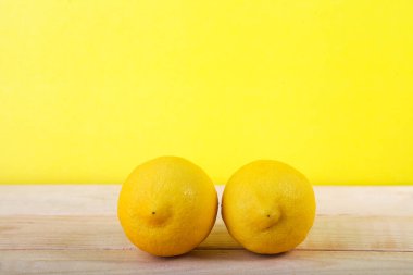 Tahta ve sarı arka planda taze limon meyvesi