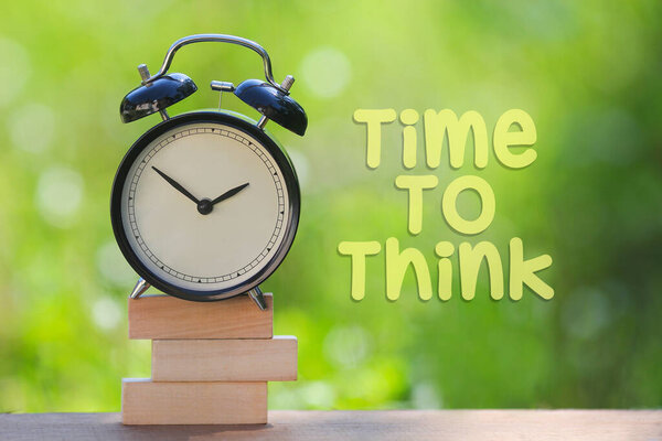Чёрный будильник со словом "Время подумать". Концепция времени