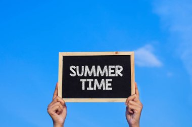 YAZ Time / Man mavi gökyüzü arka planında küçük bir karatahta tutuyor