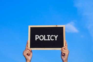 POLICY / Man mavi gökyüzü arka planında küçük bir karatahta tutuyor