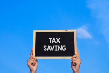 Vergi Tasarruf / Adam mavi gökyüzü arka planında küçük bir karatahta tutuyor