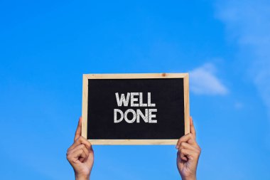 İyi iş çıkardın / Adam mavi gökyüzü arka planında küçük bir karatahta tutuyor