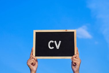 CV / Man mavi gökyüzü arka planında küçük bir karatahta tutuyor