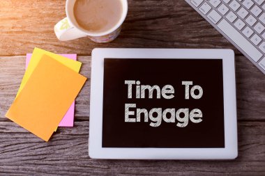 Bağlanma Zamanı Tableti ve ahşap arka planda bir fincan kahve