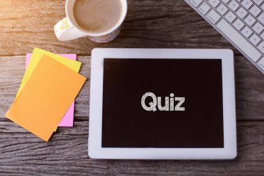 Testli tablet ve tahtadan arka planda bir fincan kahve.