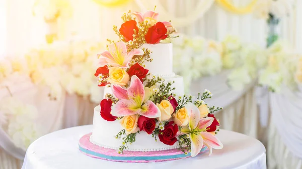 Beautiful white wedding cake with red roses as decoration