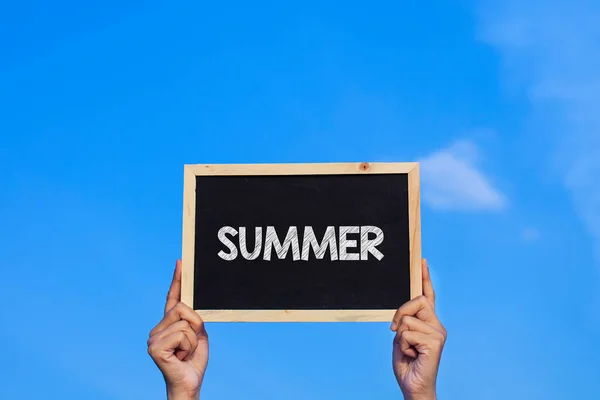 Summer Man青い空を背景に小さな黒板を持つ男 — ストック写真
