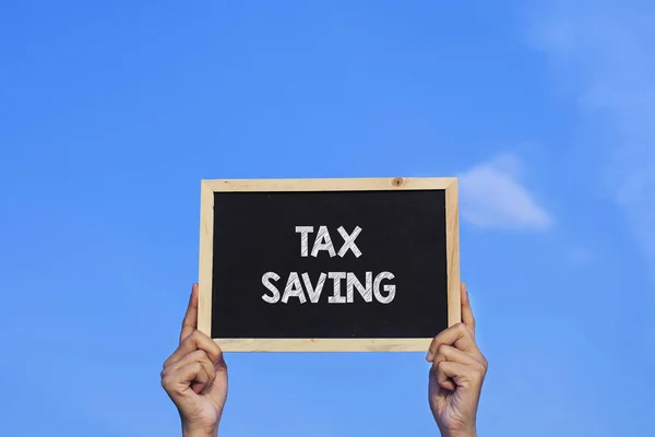 Tax Saving Man青い空を背景に小さな黒板を持つ — ストック写真