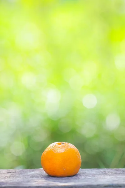 Orange fruit and slice on wooden and green background, selective focus shallow DOF