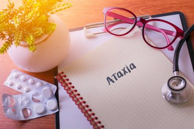Ataxia kelimelerini tıbbi kavram olarak içeren not defterine stetoskop