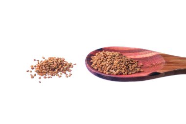 Beyaz arka planda izole edilmiş pirinç kaşıkta çemen ağacı tohumları