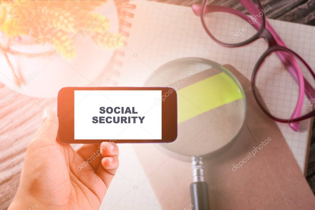 Business Concept : SOCIAL SECURITY WORD ON smartphone with office table background