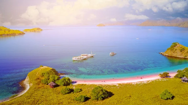 Flores 'te bir turist ve yatı olan pembe bir plaj manzarası.