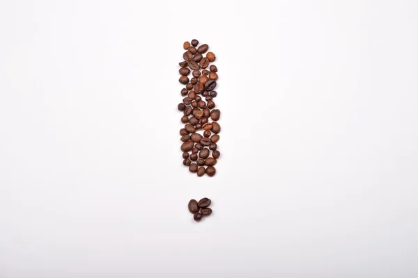 Coffee beans arranged in the shape of a exclamation mark on whit — Stock Photo, Image