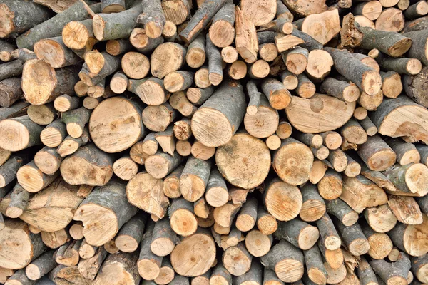 Bûches de bois écorcées brutes dans une cour de halage et de stockage du bois. Bois bruts empilés et prêts à l'emploi — Photo