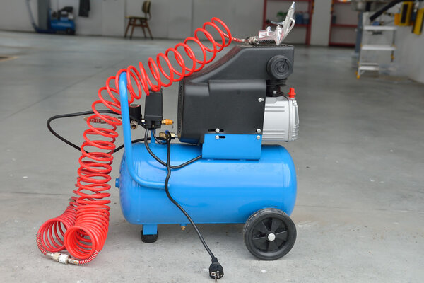 Blue pump compressor for washing cars, indoor. Cleaning concept.