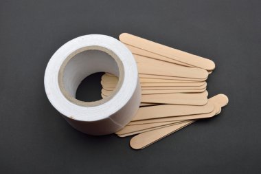 Birçok tahta spatula ve balmumu depila için kağıt rulosunun resmi