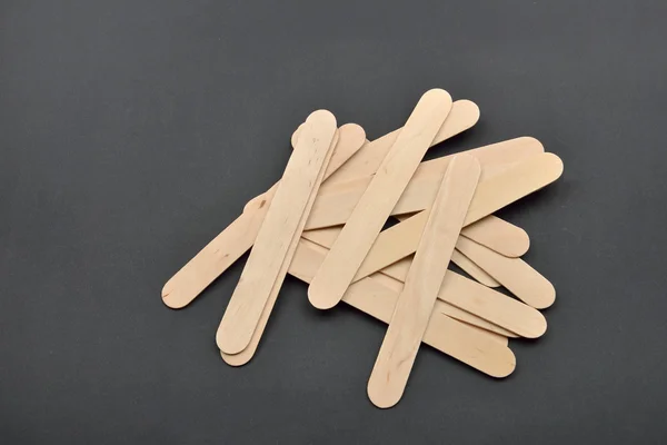 Photo de nombreuses spatules en bois pour l'épilation à la cire sur le dos noir — Photo