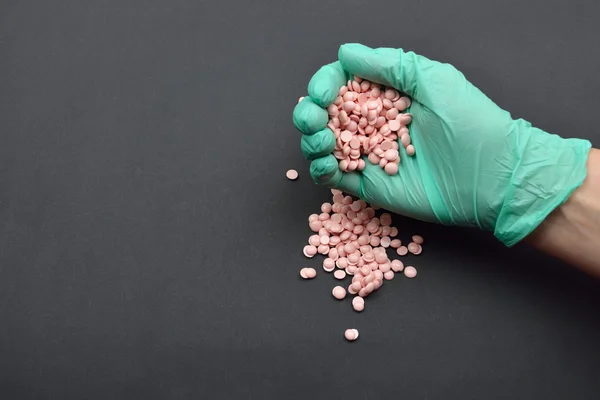 Beauticians hand with green glove holding pink disposable wax on — Stock Photo, Image