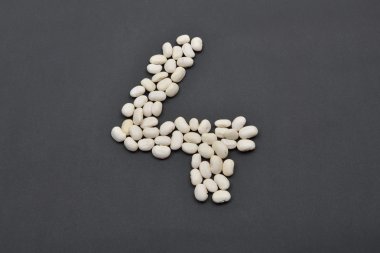 Siyah arka plan üzerine beyaz fasulye yapılmış dört numara. Gıda vega