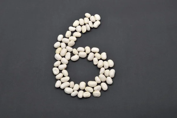 Number six made from white beans on black background. Food vegan — Stock Photo, Image