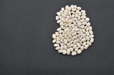 Büyük fasulye siyah arka plan üzerine beyaz fasulye yapılmıştır. Yiyecek vegan