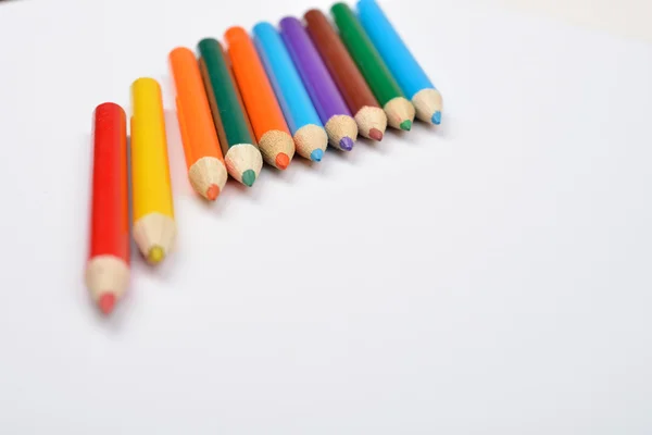 Photo rapprochée de nombreux petits crayons de couleur sur fond blanc — Photo
