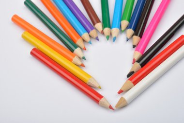 Close up picture of colored pencil crayons arranged inshape of h