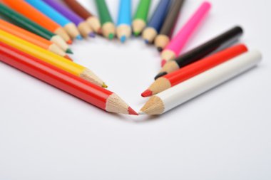 Close up picture of colored pencil crayons arranged inshape of h