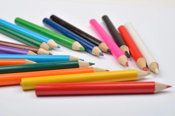 Foto da vicino di molti pastelli a matita colorati su bianco — Foto Stock