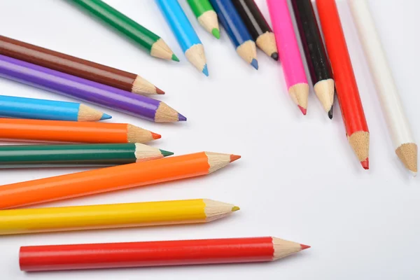 Foto da vicino di molti pastelli a matita colorati su bianco — Foto Stock