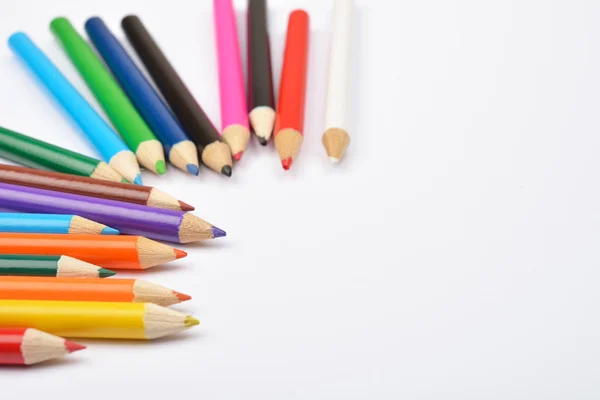 Foto da vicino di molti pastelli a matita colorati su bianco — Foto Stock