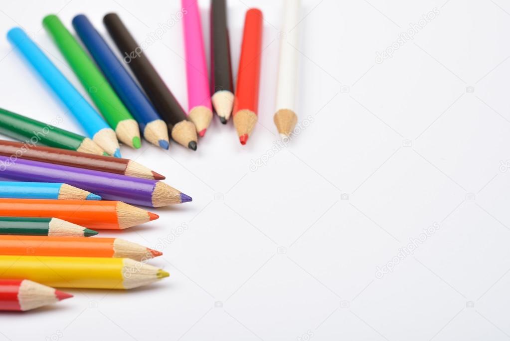 Close up picture of many colored pencil crayons on white
