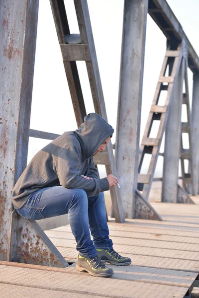 Tänkare tonåring i depression sitter på bron vid den — Stockfoto