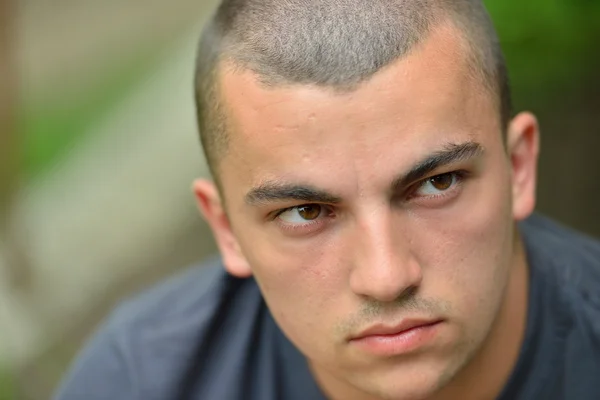 Portrait of serious and sad handsome young man outdoors in natur — Stock Photo, Image