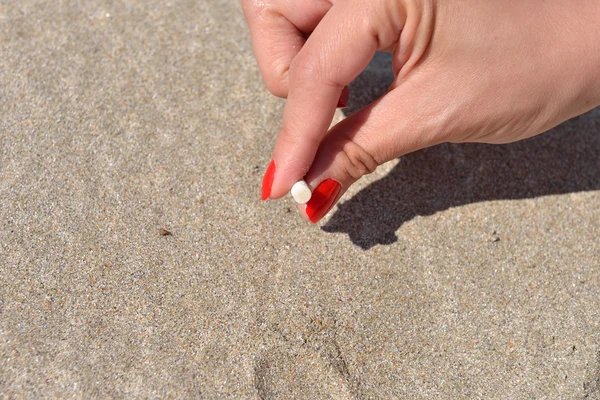 Las mujeres apagan a mano el cigarrillo en la arena de la playa. Quitti. — Foto de Stock