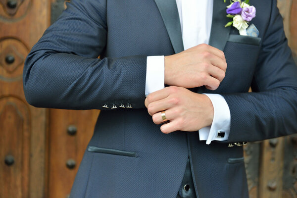 Hands of wedding groom in a elengant suit getting ready. Details