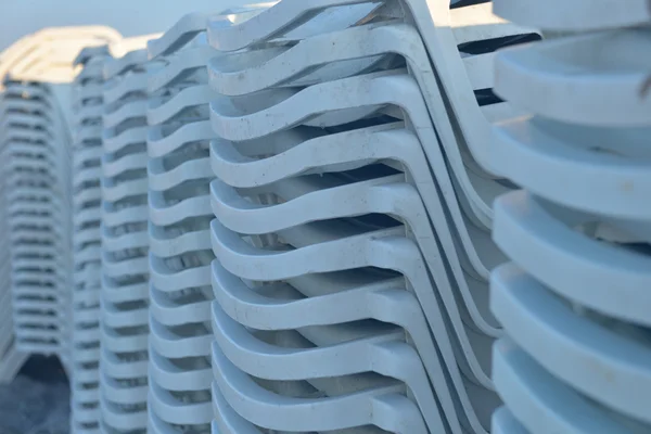 Close up of sunbeds on the beach stacked, ready to be put on the — Stock Photo, Image