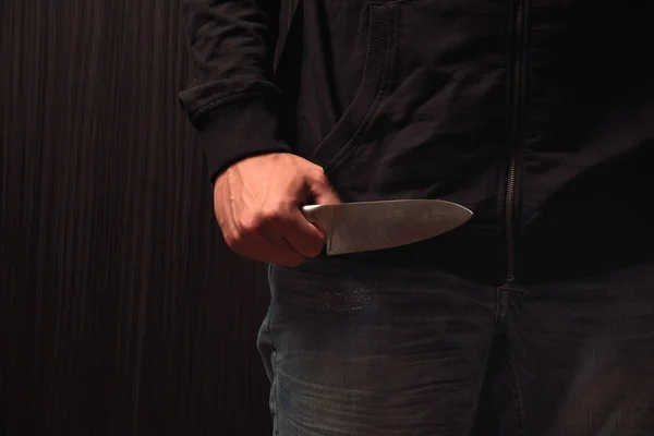 Acercamiento de una mano joven, sosteniendo un cuchillo, a punto de atacar, o — Foto de Stock