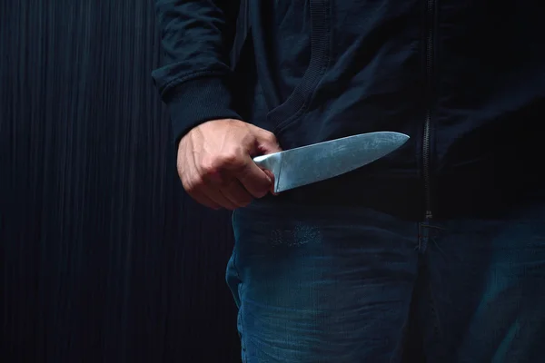 Primo piano di un giovane uomo, con un coltello in mano, che sta per attaccare, o Fotografia Stock