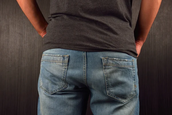 Parte posterior de un joven vestido con una camiseta gris en blanco, de pie en un semental —  Fotos de Stock