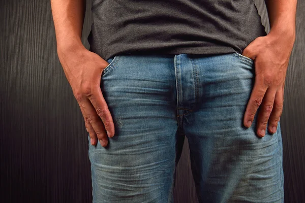 Cerca de las manos con los dedos grandes en los bolsillos de su je azul — Foto de Stock