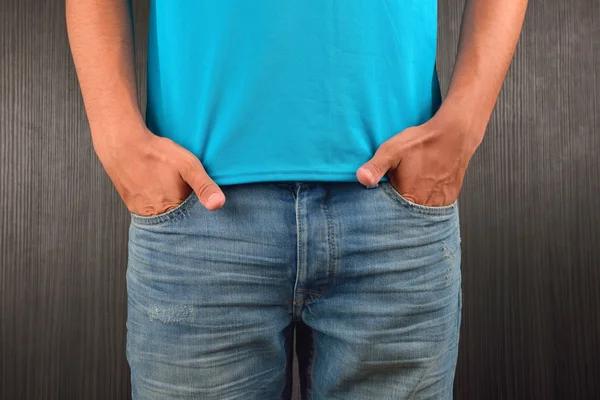 Junger Mann mit linker Hand in der Tasche seiner blauen Jeans, — Stockfoto