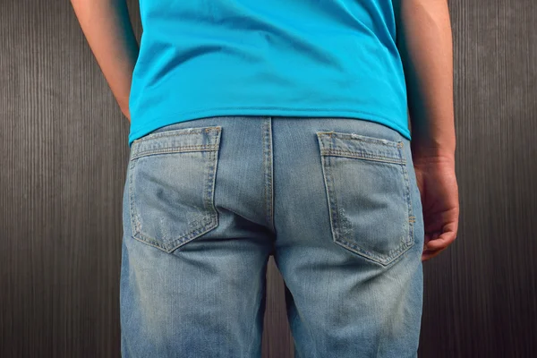 Bak av ung man bär blå blank t-shirt, stående i en stud — Stockfoto