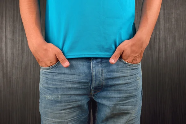 Ung man med händerna i fickan blå jeans, iklädd blå t — Stockfoto