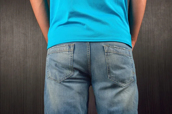 Detrás de un joven vestido con una camiseta azul en blanco, de pie en un semental —  Fotos de Stock