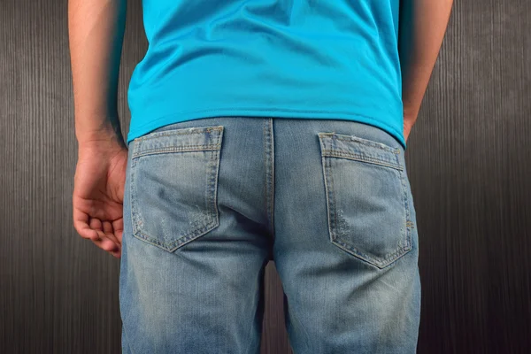 Detrás de un joven vestido con una camiseta azul en blanco, de pie en un semental — Foto de Stock