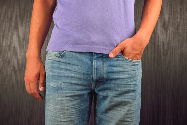 Молодой человек с левой рукой в кармане синих джинсов, носить — стоковое фото